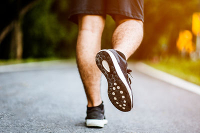 Low section of man running on road