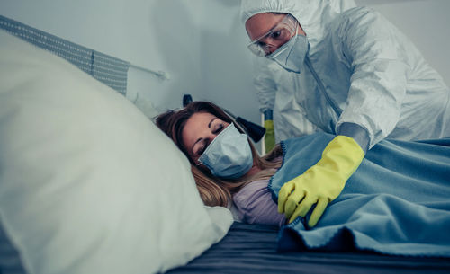 Midsection of friends lying on bed