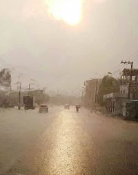 Cars on road against sky during rainy season