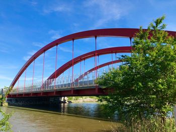 Bridge over river in city against sky