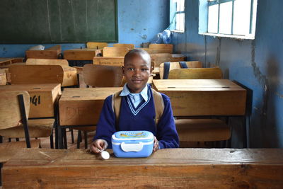 Portrait of smiling boy sitting on table