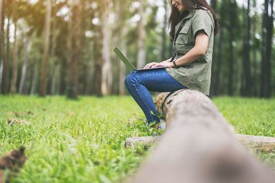 Side view of woman sitting on field