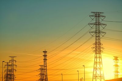 Low angle view of electricity pylon against clear sky