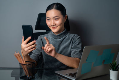 Portrait of young woman using mobile phone