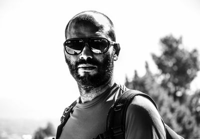 Portrait of young man wearing sunglasses against sky