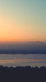 Scenic view of silhouette landscape against orange sky