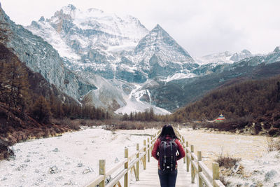 Full length of woman on snow covered mountains against sky