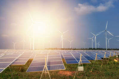 Wind turbines on field against sky