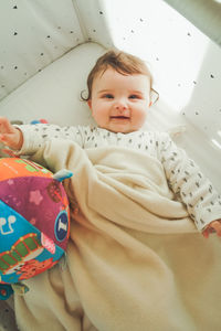 High angle view of cute baby lying on bed