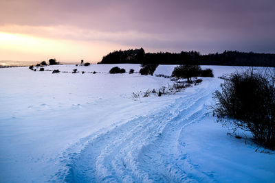 Scenic view of frozen lake against sky during sunset