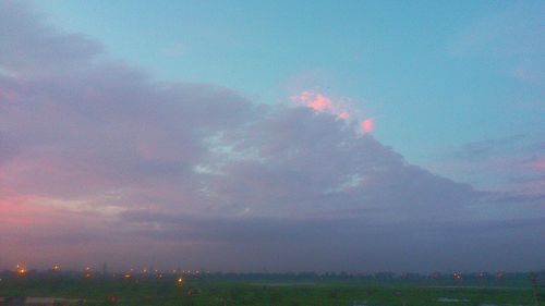 Scenic view of field against cloudy sky