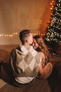 A romantic couple in love celebrates christmas holidays and new year in a cozy house at night