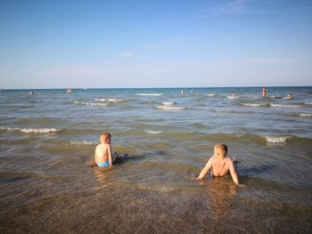 Friends at beach against sky