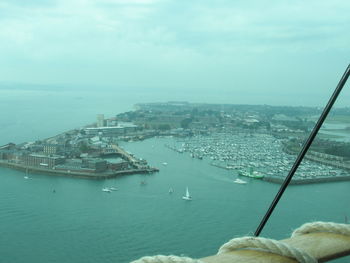 High angle view of sea by cityscape against sky