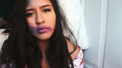 Close-up of young woman with messy make-up at home