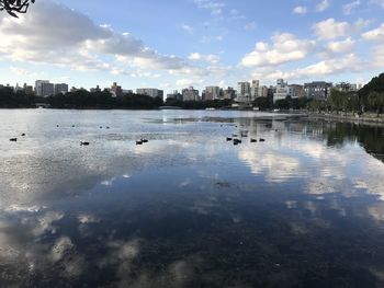 Scenic view of lake by buildings against sky