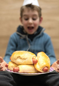 Happy boy holding food in plate