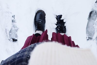 Low section of man standing on snow