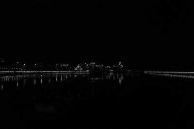 Illuminated water against clear sky at night