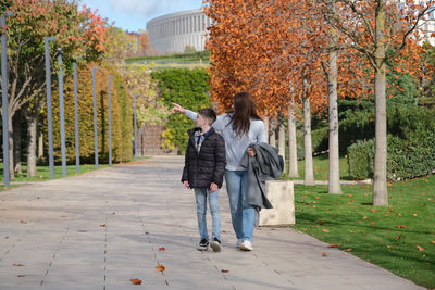 Rear view of woman walking on footpath