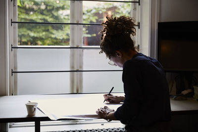 Side view of confident female architect planning in office