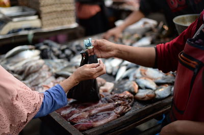 Midsection of man preparing food for sale at market