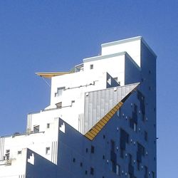 Low angle view of buildings against clear blue sky