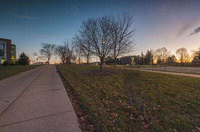 View of footpath by road against sky