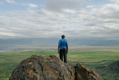 A hiker at a scenic view point against the background of lake natron in tanzania