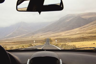 Close-up of car on road against mountains