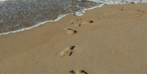 High angle view of footprints on sand at beach