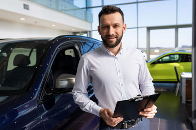 Portrait of car dealer at showroom