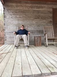 Portrait of boy sitting on armchair at porch