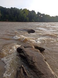 Scenic view of rocks by river against sky