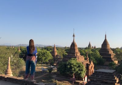 Rear view of woman standing against temples