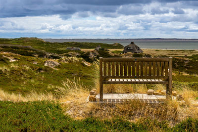 Gazebo on field by sea against sky