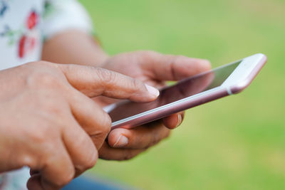 Midsection of person using mobile phone outdoors