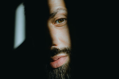 Close-up of young man against black background