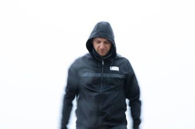 Portrait of young man standing against white background