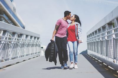 Rear view of couple walking on footbridge