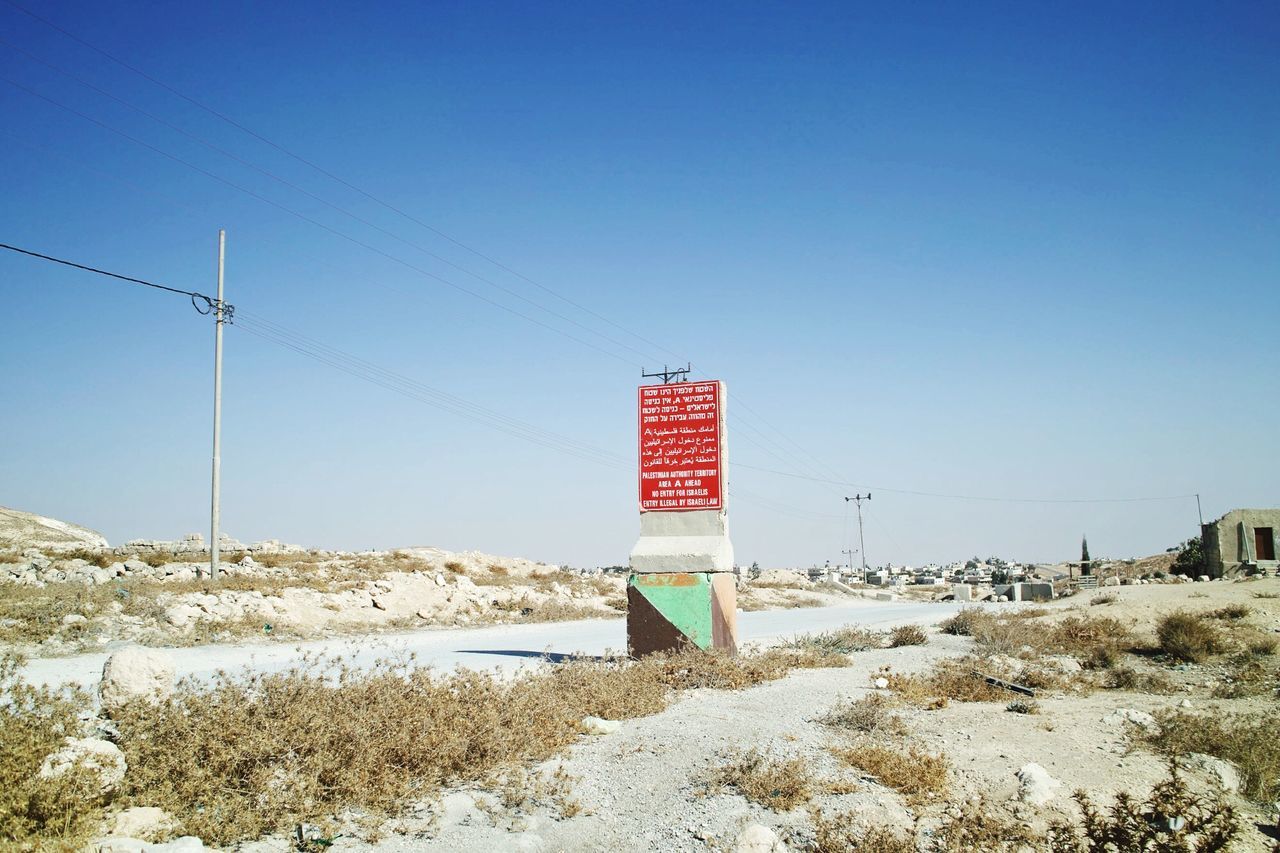 clear sky, blue, copy space, guidance, built structure, water, red, sea, tranquility, beach, day, architecture, tranquil scene, no people, sunlight, outdoors, nature, protection, sand, safety