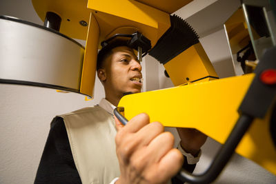 Close-up of young man using machinery