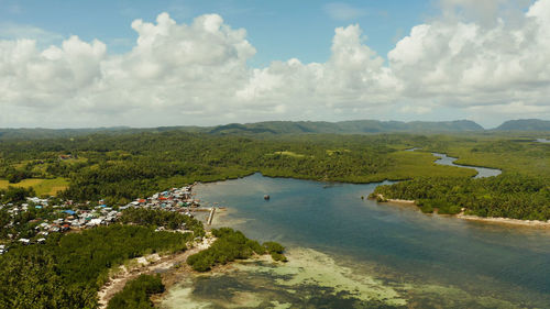 Town in wetlands and mangroves on the ocean coastline from above. siargao island, philippines.