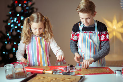 Siblings preparing cookies at home