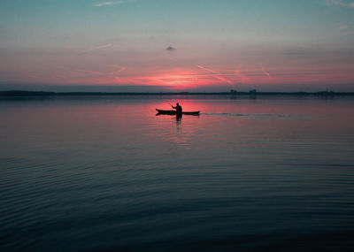 Scenic view of person canoeing at dusk