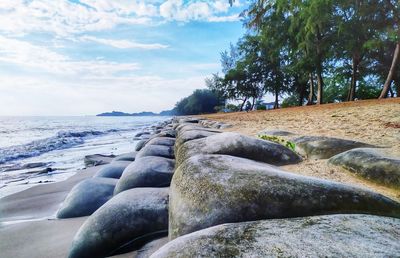 Rocks by sea against sky