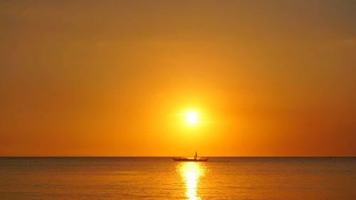 Scenic view of sea against orange sky