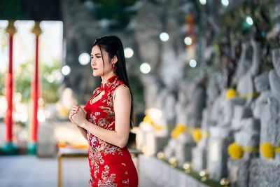Side view of young woman standing outdoors