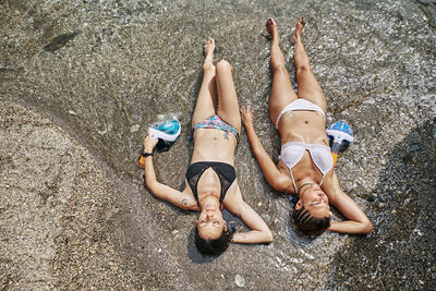 High angle view of women lying on beach