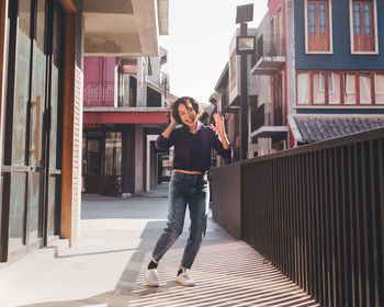 Portrait of woman standing against building